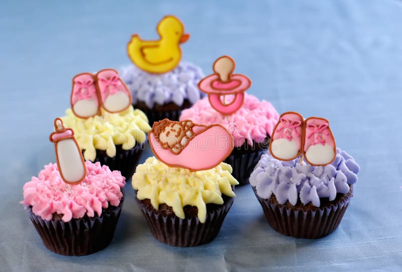 Chocolate cupcakes frosted with buttercream, decorated with cute pink baby-themed royal icing toppers. Chocolate cupcakes frosted with buttercream, decorated with cute pink baby-themed royal icing toppers.