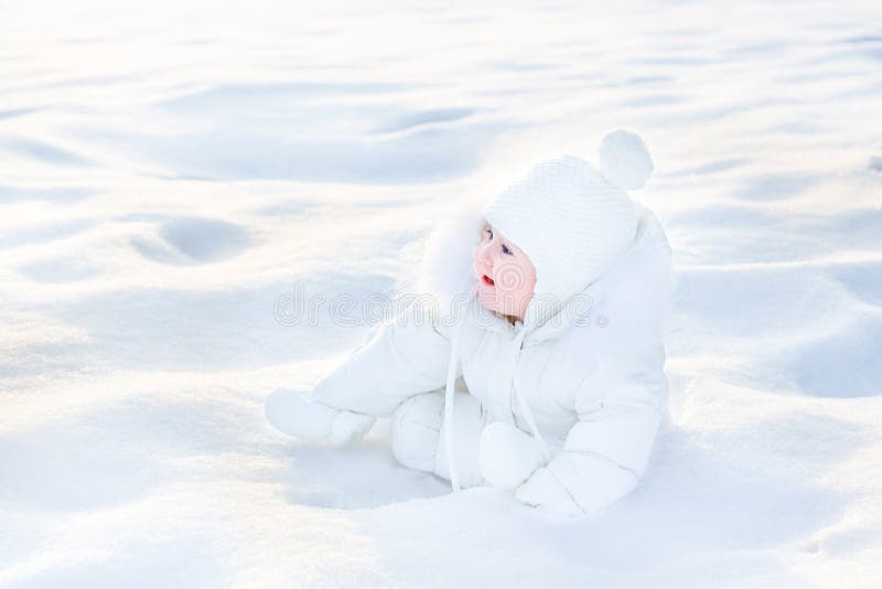 Leuke gelukkige baby in sneeuw op zonnige de winterdag