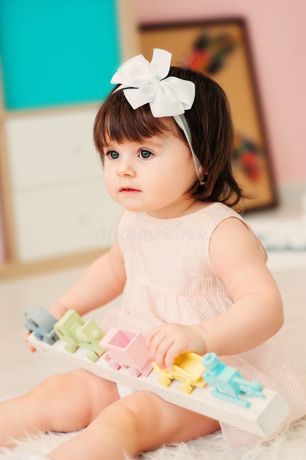 Leuke gelukkige 1 éénjarige babymeisje het spelen met houten speelgoed thuis royalty-vrije stock afbeeldingen Leuke gelukkige 1 éénjarige babymeisje het spelen met houten speelgoed thuis royalty-vrije stock afbeeldingen