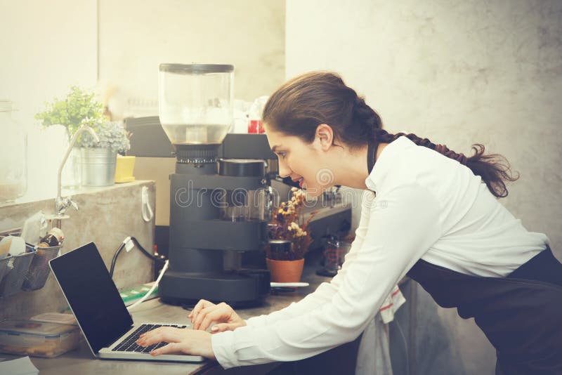 Leuke Kaukasische bezig het werken met laptop aan de teller van de koffiewinkel stock foto's Leuke Kaukasische bezig het werken met laptop aan de teller van de koffiewinkel stock foto's