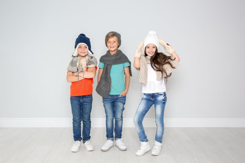 Leuke kinderen in warme kleren die dichtbij lichte muur stellen De Viering van Kerstmis royalty-vrije stock fotografie Leuke kinderen in warme kleren die dichtbij lichte muur stellen De Viering van Kerstmis royalty-vrije stock fotografie