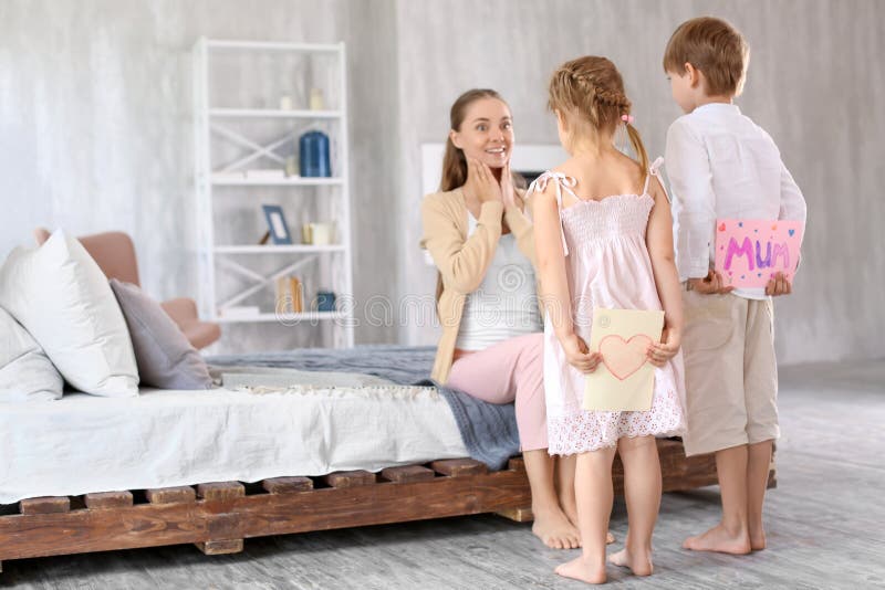 Leuke kleine kinderen die groetkaarten voor hun moeder achter rug thuis verbergen royalty-vrije stock afbeeldingen Leuke kleine kinderen die groetkaarten voor hun moeder achter rug thuis verbergen royalty-vrije stock afbeeldingen