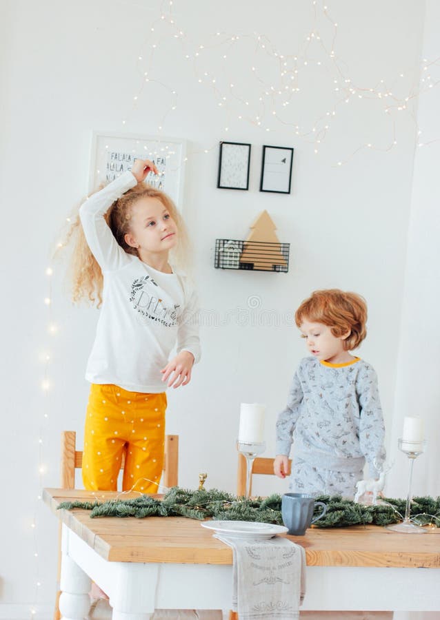 Leuke zuster en broer in pyjama's bij feestelijke lijst, Scandinavië royalty-vrije stock afbeelding Leuke zuster en broer in pyjama's bij feestelijke lijst, Scandinavië royalty-vrije stock afbeelding