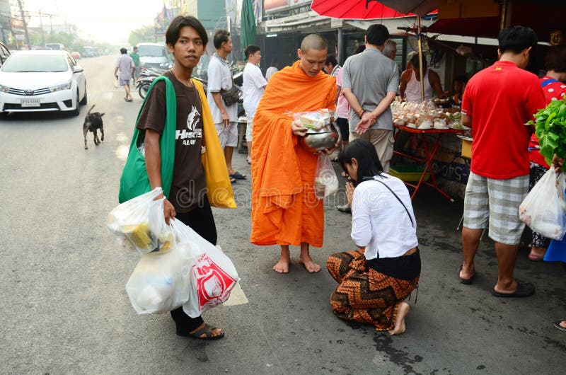 Leute beten mit Mönch und setzen Lebensmittelangebote zur buddhistischen Almosenschüssel lizenzfreies stockbild Leute beten mit Mönch und setzen Lebensmittelangebote zur buddhistischen Almosenschüssel lizenzfreies stockbild