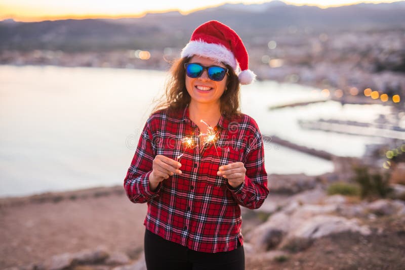 Leute, Schönheit und Weihnachtskonzept - Schönheit in der Sonnenbrille und in der Weihnachtsmann-Hutholding funkelt stockbilder Leute, Schönheit und Weihnachtskonzept - Schönheit in der Sonnenbrille und in der Weihnachtsmann-Hutholding funkelt stockbilder