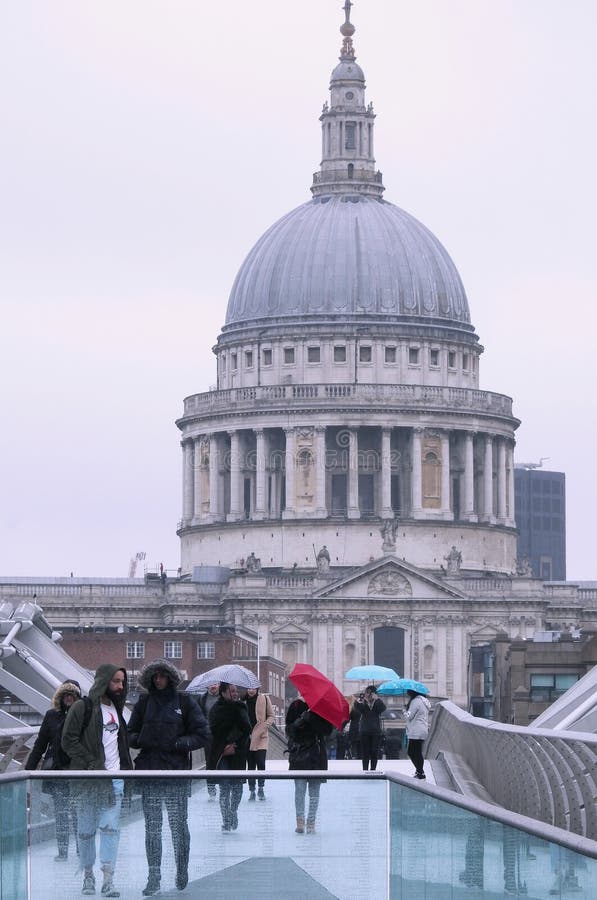 Leute, welche die Jahrtausend-Brücke, London im Regen mit bunten Regenschirmen gegen einen Hintergrund von St- Paul` s Kathedrale lizenzfreies stockbild Leute, welche die Jahrtausend-Brücke, London im Regen mit bunten Regenschirmen gegen einen Hintergrund von St- Paul` s Kathedrale lizenzfreies stockbild