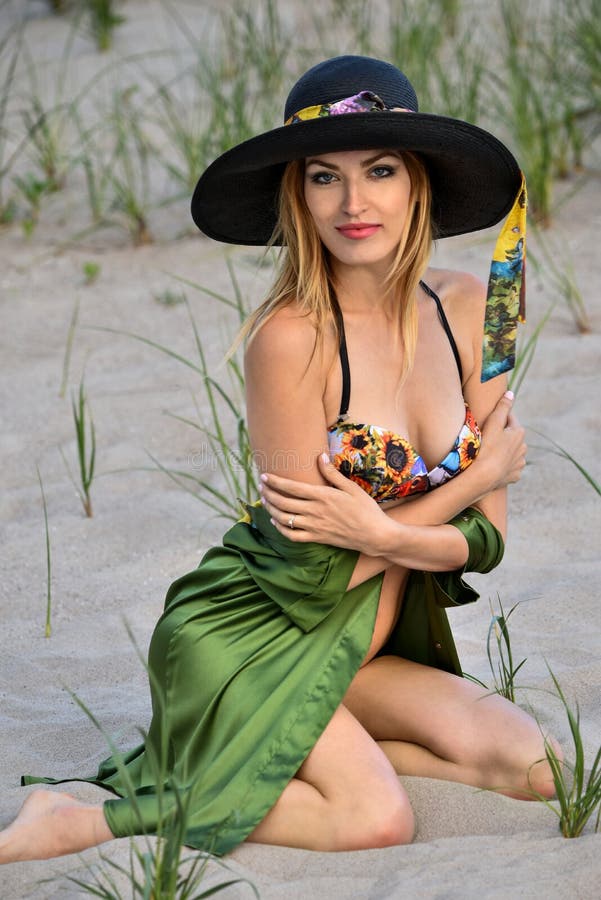 Levantamento modelo do biquini louro 'sexy' na praia, na camisa colorida vestindo do roupa de banho, a de seda e no chapéu imagem de stock Levantamento modelo do biquini louro 'sexy' na praia, na camisa colorida vestindo do roupa de banho, a de seda e no chapéu imagem de stock