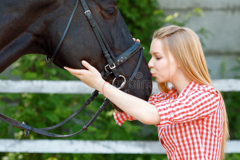 Levendig jong meisje die het paard kussen royalty-vrije stock fotografie Levendig jong meisje die het paard kussen royalty-vrije stock fotografie