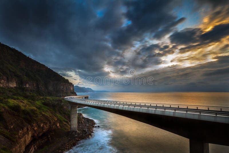 The Sea Cliff Bridge is a balanced cantilever bridge located in the northern Illawarra region of New South Wales, Australia. The bridge links the coastal villages of Coalcliff and Clifton and has two lanes of traffic, a cycleway and a walkway, the Sea Cliff Bridge boasts spectacular views and is a feature of the scenic Lawrence Hargrave Drive. The Sea Cliff Bridge is a balanced cantilever bridge located in the northern Illawarra region of New South Wales, Australia. The bridge links the coastal villages of Coalcliff and Clifton and has two lanes of traffic, a cycleway and a walkway, the Sea Cliff Bridge boasts spectacular views and is a feature of the scenic Lawrence Hargrave Drive.