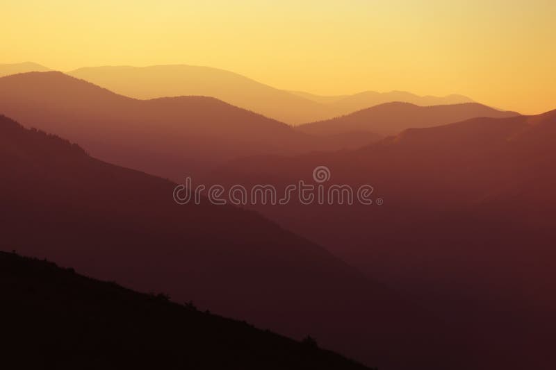 Lever de soleil au-dessus des silhouettes de montagnes photos stock Lever de soleil au-dessus des silhouettes de montagnes photos stock