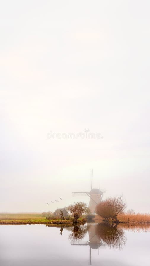 Lever de soleil brumeux et calme de moulin à vent photographie stock Lever de soleil brumeux et calme de moulin à vent photographie stock