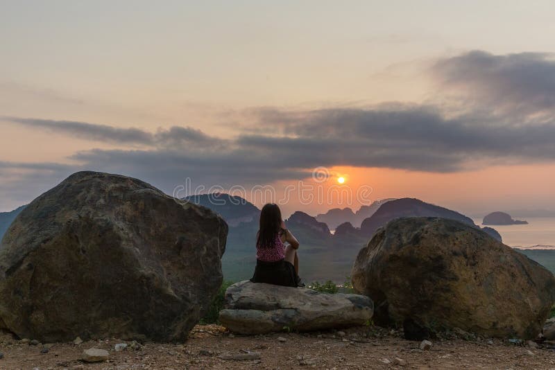 Lever de soleil de observation de femme sur la baie de Phang Nga photographie stock libre de droits Lever de soleil de observation de femme sur la baie de Phang Nga photographie stock libre de droits