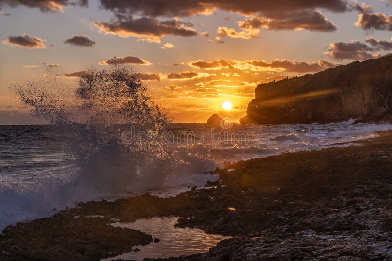 The sun rises over Little Cayman Brac off the limestone bluffs on the East End of Cayman Brac, Cayman Islands. The sun rises over Little Cayman Brac off the limestone bluffs on the East End of Cayman Brac, Cayman Islands