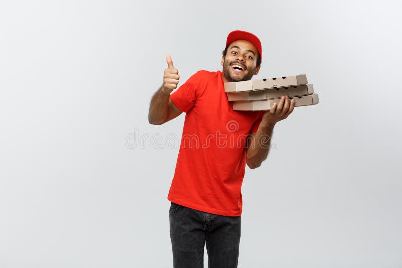 Leveringsconcept - Portret van de Knappe Afrikaanse Amerikaanse mens die van de Pizzalevering dreun tonen Geïsoleerd op Grijze st royalty-vrije stock foto's Leveringsconcept - Portret van de Knappe Afrikaanse Amerikaanse mens die van de Pizzalevering dreun tonen Geïsoleerd op Grijze st royalty-vrije stock foto's