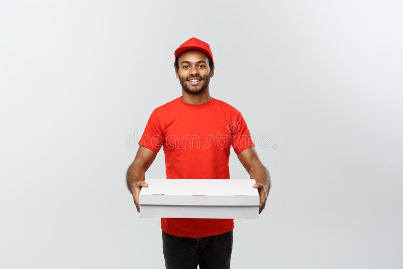 Leveringsconcept - Portret van de Knappe Afrikaanse Amerikaanse mens van de Pizzalevering Geïsoleerd op grijze studioachtergrond stock foto's Leveringsconcept - Portret van de Knappe Afrikaanse Amerikaanse mens van de Pizzalevering Geïsoleerd op grijze studioachtergrond stock foto's