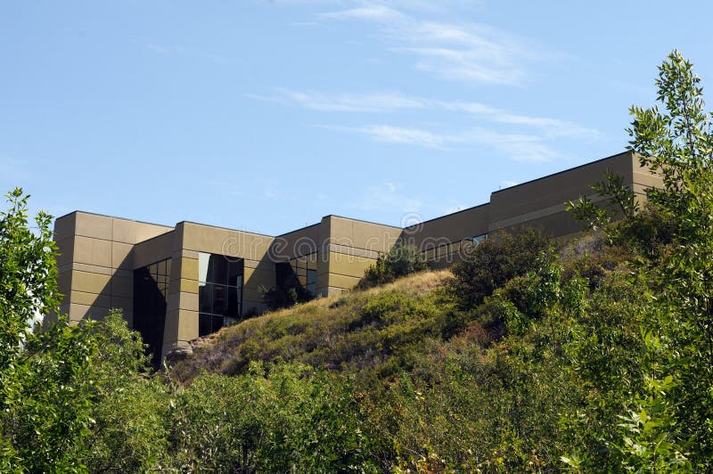 Noted modern building set against blue sky with green tree foreground. Noted modern building set against blue sky with green tree foreground