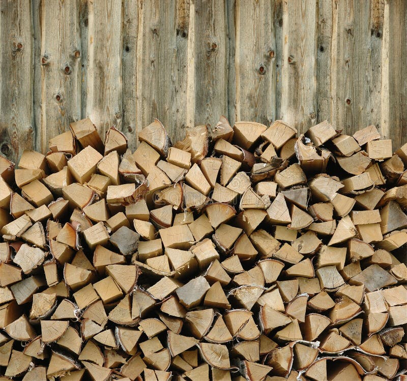 Pile of firewood against old wooden fence. Pile of firewood against old wooden fence