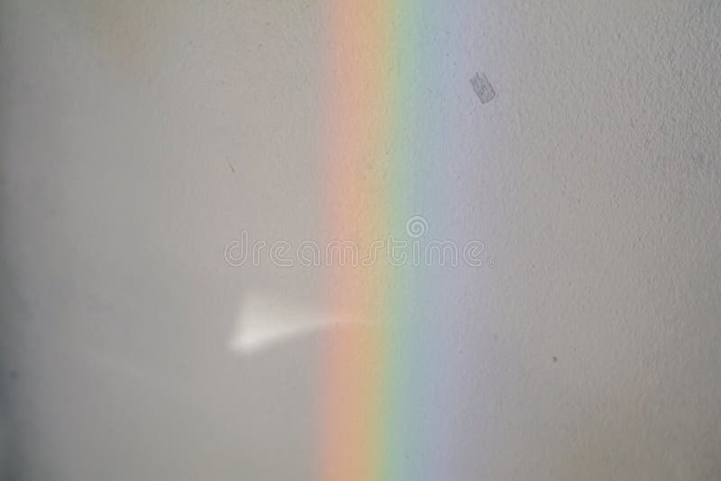 LGBT color,Close-up sun ray shining through window glass that work as prism and reflex colorful spectrum on floor.Beautiful rainbow glare spectrum lighting speculator reflection on white tree pot.