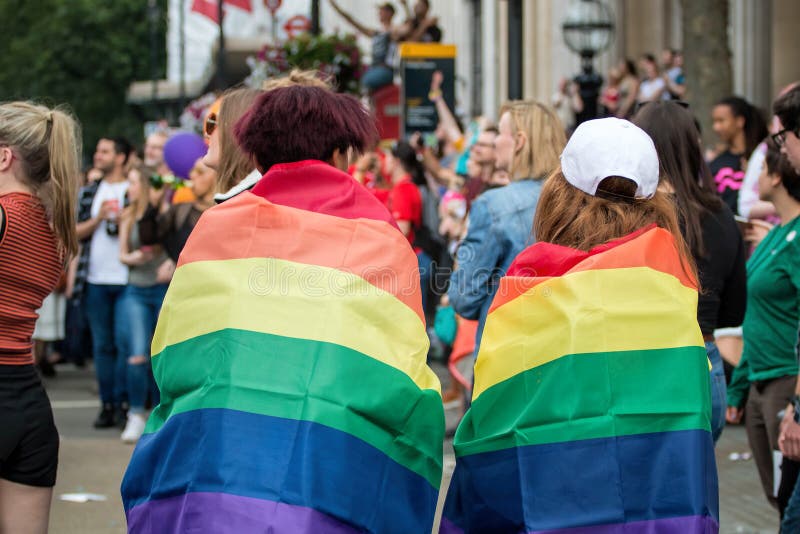 LGBT Pride Parade Two Young Woman gai enveloppé dans des drapeaux d'arc-en-ciel photos stock LGBT Pride Parade Two Young Woman gai enveloppé dans des drapeaux d'arc-en-ciel photos stock