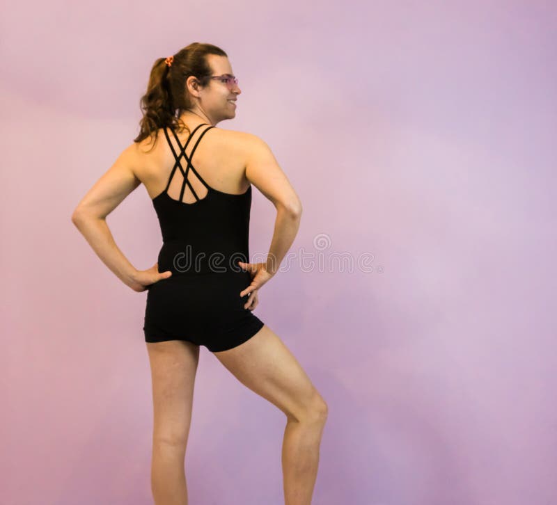LGBT transgender młoda dziewczyna pozuje w czarnym leotard z krzyżujący z powrotem, stojący w eleganckiej pozie obrazy royalty free LGBT transgender młoda dziewczyna pozuje w czarnym leotard z krzyżujący z powrotem, stojący w eleganckiej pozie obrazy royalty free