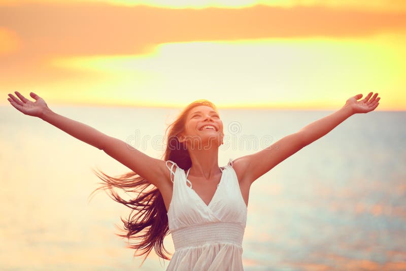 Libere a la mujer feliz que elogia la libertad en la puesta del sol de la playa imagen de archivo