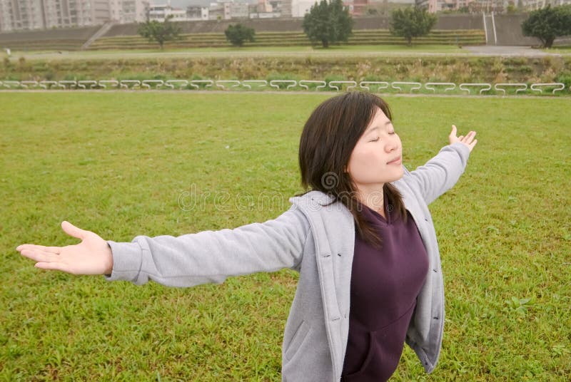 Freedom expression of Asian woman with open arms and closed eyes in outdoor of park of city. Freedom expression of Asian woman with open arms and closed eyes in outdoor of park of city.