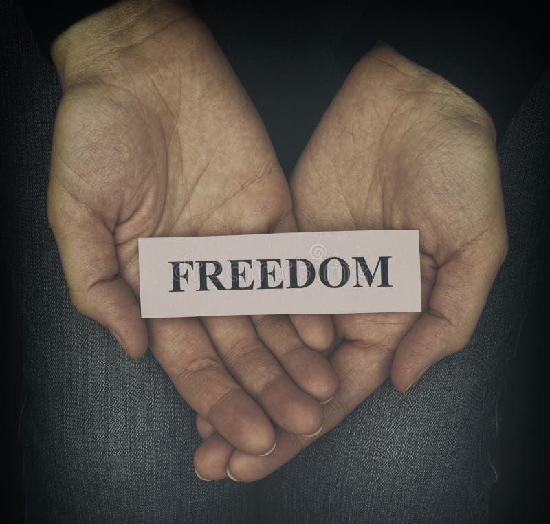 Woman holding word Freedom in her palms. Close up. Vignette. Woman holding word Freedom in her palms. Close up. Vignette.