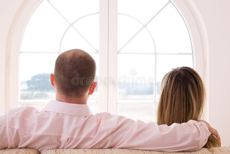 Couple sitting on the sofa in front of window/ Window on the world / freedom / new time. Couple sitting on the sofa in front of window/ Window on the world / freedom / new time