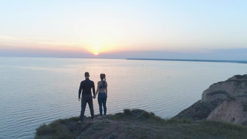 Liberté spirituelle, couple heureux de sports appréciant le calme en nature près de la mer dans la position de coucher du soleil