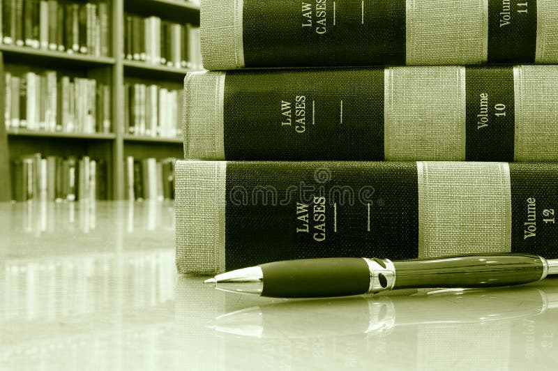 Lawbooks and a pen on a table, in a library. Lawbooks and a pen on a table, in a library