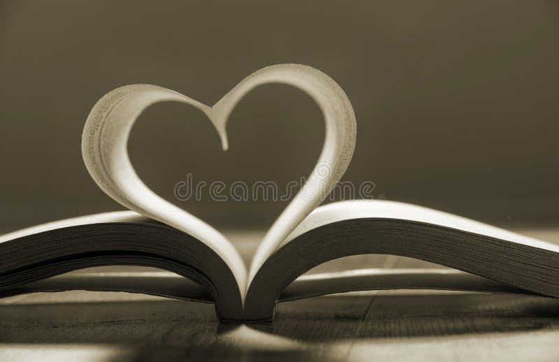 Libro aperto con le pagine che formano forma del cuore. fotografia stock Libro aperto con le pagine che formano forma del cuore. fotografia stock
