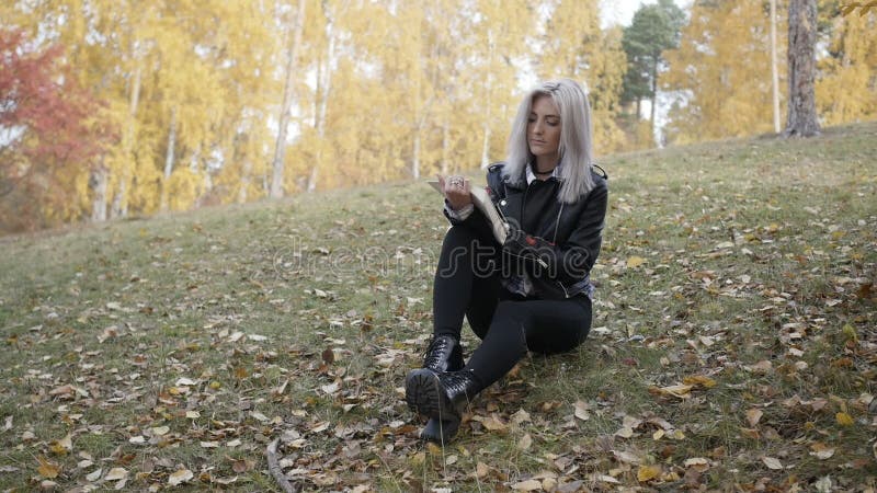 Libro de lectura bonito de la mujer en parque del otoño