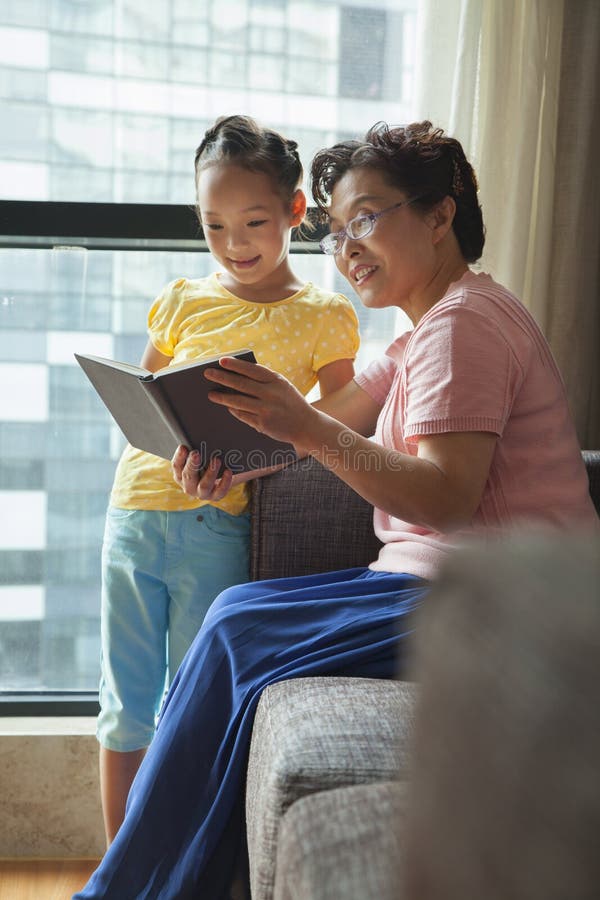 Libro de lectura de la abuela a su nieta imagen de archivo