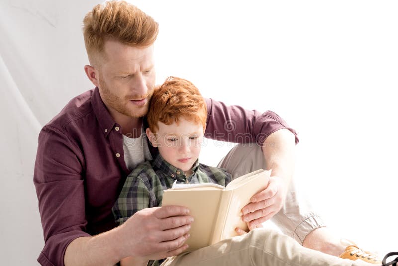 Libro de lectura del padre y del hijo del pelirrojo junto imagenes de archivo