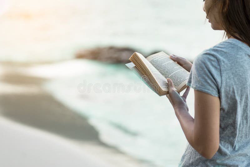 Libro de lectura de la mujer en la playa de la arena imagen de archivo Libro de lectura de la mujer en la playa de la arena imagen de archivo