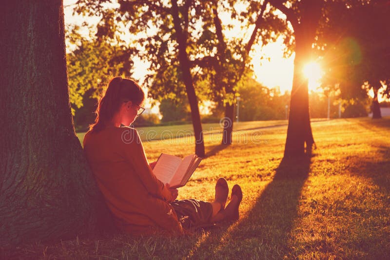 Libro di lettura della ragazza al parco fotografia stock libera da diritti Libro di lettura della ragazza al parco fotografia stock libera da diritti