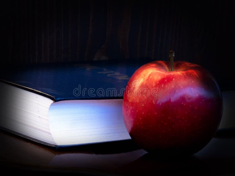 Libro e mela su fondo scuro fotografie stock libere da diritti Libro e mela su fondo scuro fotografie stock libere da diritti