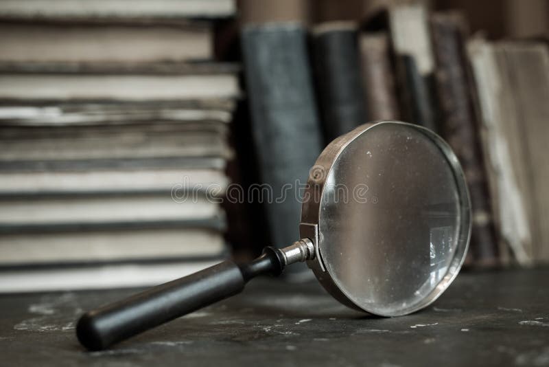 Antique books with magnifying glass. Old leather bound vintage books in a row. Antique books with magnifying glass. Old leather bound vintage books in a row