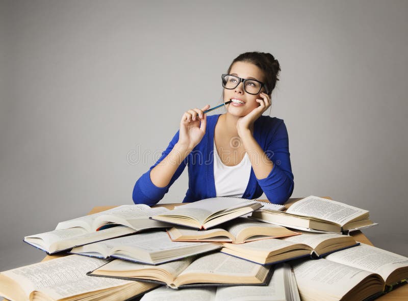 Libros de Woman Thinking Open del estudiante, reflexionando los vidrios de la muchacha foto de archivo libre de regalías Libros de Woman Thinking Open del estudiante, reflexionando los vidrios de la muchacha foto de archivo libre de regalías