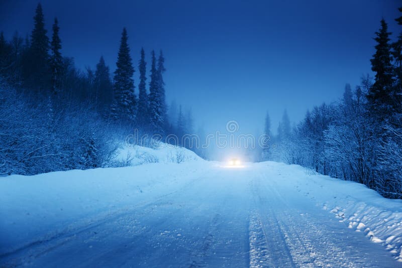 Lichter des Autos und der Winterstraße stockfotografie Lichter des Autos und der Winterstraße stockfotografie