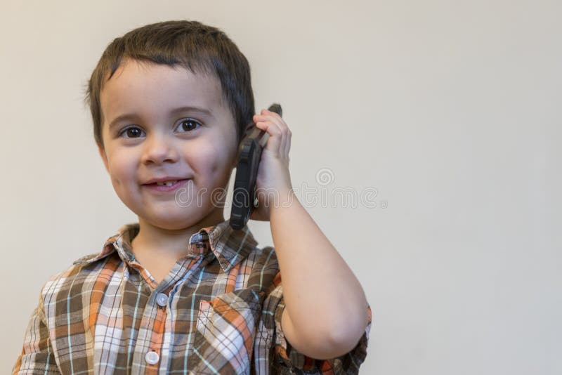 ?liczna ch?opiec opowiada telefonem kom?rkowym na lekkim tle Szcz??liwa ch?opiec pozycja i opowiada? na smartphone w domu zdjęcie stock ?liczna ch?opiec opowiada telefonem kom?rkowym na lekkim tle Szcz??liwa ch?opiec pozycja i opowiada? na smartphone w domu zdjęcie stock