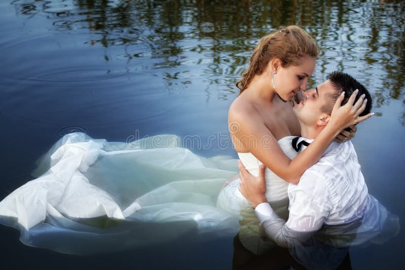 Liebe und Neigung - Kuss des verheirateten Paars im Wasser lizenzfreies stockbild Liebe und Neigung - Kuss des verheirateten Paars im Wasser lizenzfreies stockbild
