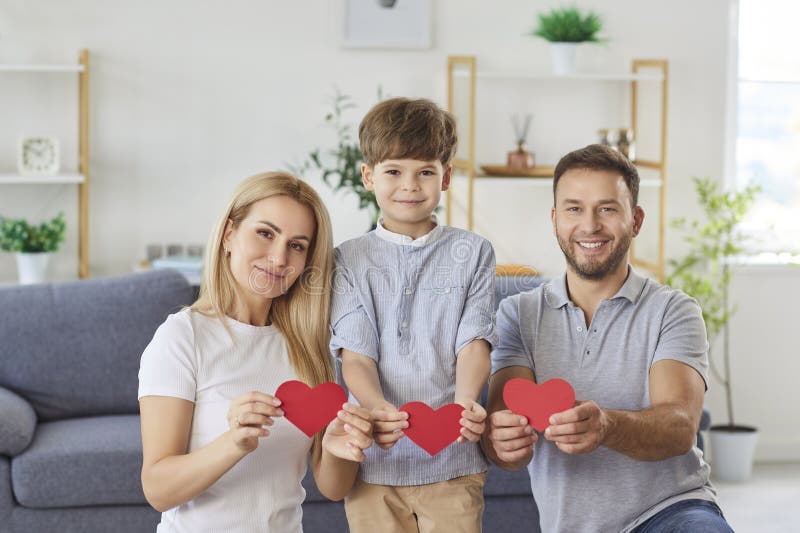 Liebe zu einer freundlichen Familie, die ein rotes Herz in Händen hält und die Unterstützung der Einheit zeigt stockfotos