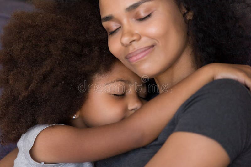 Liebende einzelne schwarze Mutter umarmt nette Tochterfühlungs-Weichheitsverbindung