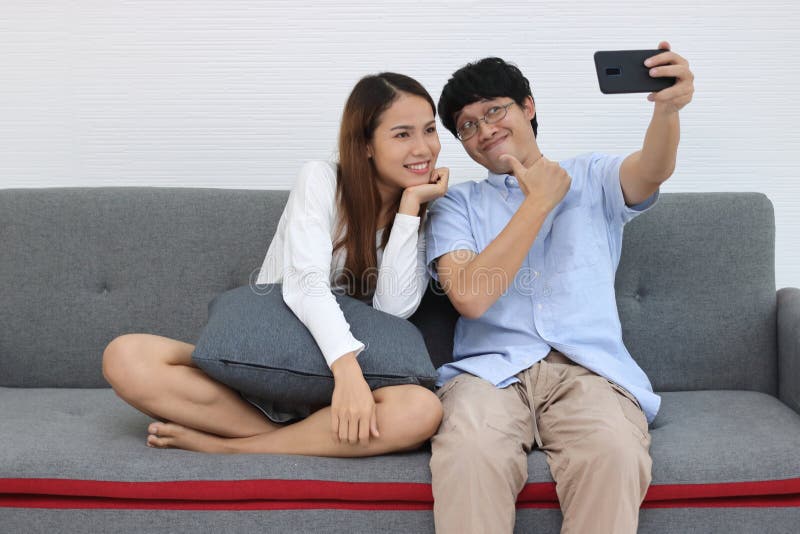 Liebes romantisches, junges asiatisches Ehepaar, das im Wohnzimmer fotografiert oder selfie Konzept der Liebe und Romantik lizenzfreie stockbilder Liebes romantisches, junges asiatisches Ehepaar, das im Wohnzimmer fotografiert oder selfie Konzept der Liebe und Romantik lizenzfreie stockbilder