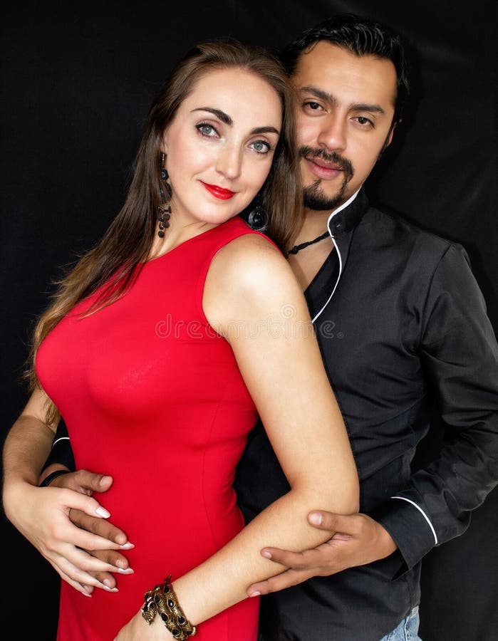 Liebesgeschichte, Mann und Frau Brunettes, die auf einem schwarzen Hintergrund umarmen stockfotografie Liebesgeschichte, Mann und Frau Brunettes, die auf einem schwarzen Hintergrund umarmen stockfotografie