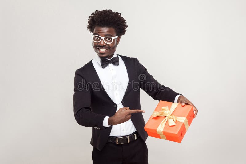 Liebevolle Paare Afrikanischer Geschäftsmann, der Finger auf Geschenkbox zeigt lizenzfreie stockfotografie Liebevolle Paare Afrikanischer Geschäftsmann, der Finger auf Geschenkbox zeigt lizenzfreie stockfotografie