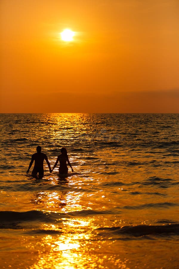 Liebevolle Paare bei Sonnenuntergang im Meer stockbilder Liebevolle Paare bei Sonnenuntergang im Meer stockbilder