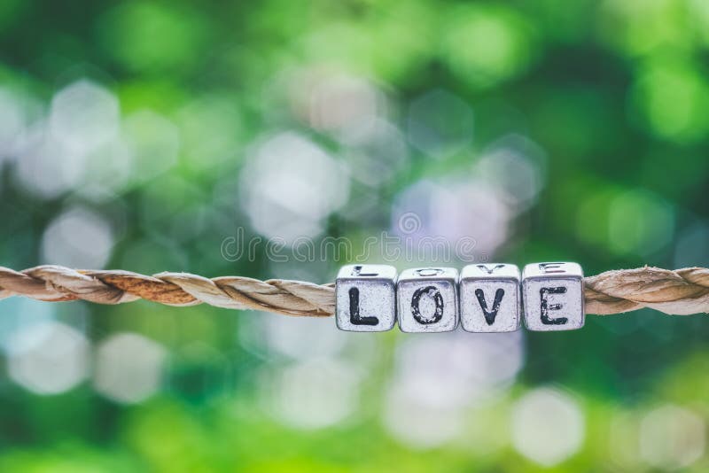 Liefdewoord het hangen door kabel met mooie groene aard bokeh achter stock foto's Liefdewoord het hangen door kabel met mooie groene aard bokeh achter stock foto's