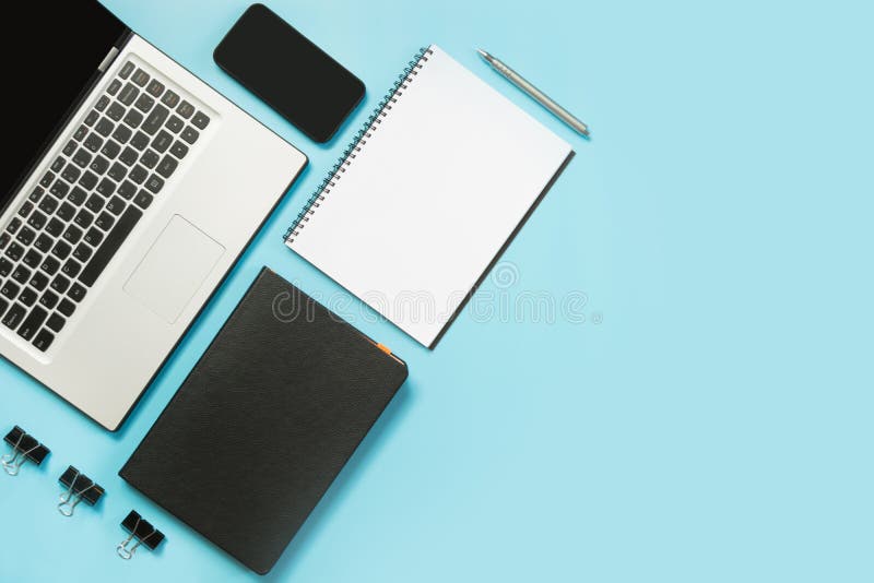 Lieu de travail avec l'accessoire d'ordinateur portable, blanc et noir ouvert sur la table bleue L'espace de vue supérieure et de images stock Lieu de travail avec l'accessoire d'ordinateur portable, blanc et noir ouvert sur la table bleue L'espace de vue supérieure et de images stock